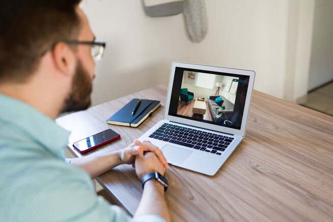 man looking at 360 tour on laptop